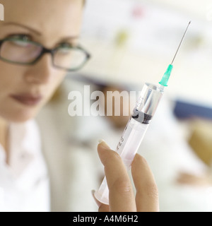 Nurse holding up syringe in front of patient Banque D'Images