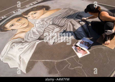 Un artiste met la touche finale à une peinture à la craie créés directement sur la rue d'un programme annuel des arts fair à San Diego. Banque D'Images