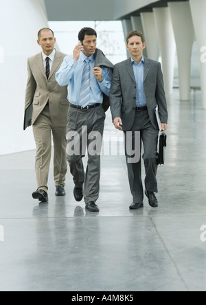 Trois hommes d'un de using cell phone Banque D'Images