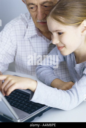 Grand-père et sa petite-fille looking at laptop computer Banque D'Images