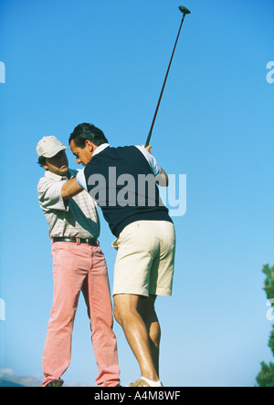 L'homme de prendre des leçons avec un instructeur de golf Banque D'Images