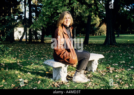 Femme (app. 35) ASSIS SUR LE BANC EN PIERRE Banque D'Images