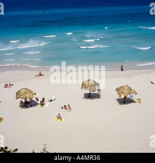 Vue plongeante sur la plage de sable blanc de Varadero avec trois parasols en chaume province de Matanzas Cuba Banque D'Images