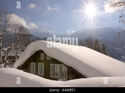 La neige profonde sur le mur et le toit chalet étincelant dans le soleil de nuit frost à Engelberg en Suisse centrale Banque D'Images