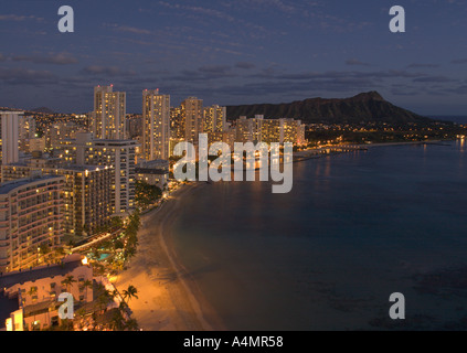 Vue vers le sud le long du rivage de la plage de Waikiki en courbe beachfront hôtels bâtiments allumé après le coucher du soleil Honolulu Oahu Hawaii Banque D'Images