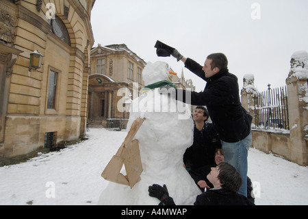 Les élèves construisent un bonhomme de neige dans le parc du Sheldonian Theatre Oxford Banque D'Images
