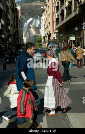 Basques en vêtements traditionnels et modernes sur le passage piétons, Musée Guggenheim de Bilbao, l'arrière-plan, Pays Basque Banque D'Images