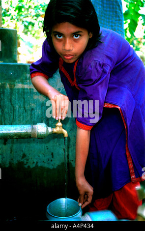 Jeune fille recueille l'eau dans le pot d'un village du Bangladesh rural réservoir Banque D'Images