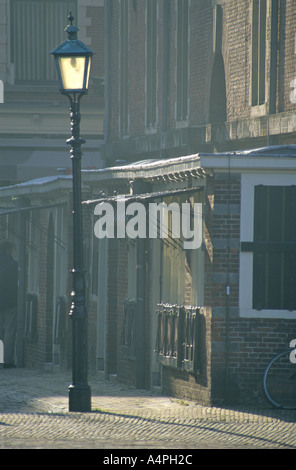 Vintage iron réverbère sur un coin de la place principale (Grote Markt) médiévale à Haarlem aux Pays-Bas. Retour de la lumière dans le brouillard brumeux. Banque D'Images