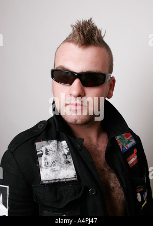 Coupe de cheveux de Mohican jeune homme age entre 20 et 25 portant des lunettes de soleil tourné en studio sur un fond blanc Banque D'Images