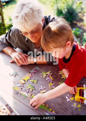 Grand-mère et petit-fils de faire un casse-tête à l'extérieur sur tabe Banque D'Images