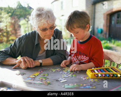 Grand-mère et l'enfant faire puzzle en dehors sur la table Banque D'Images