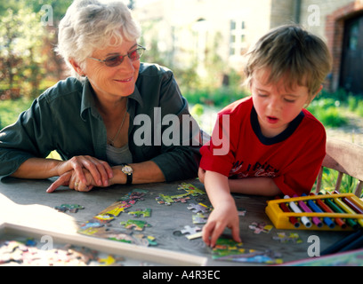 Grand-mère et l'enfant faire puzzle en dehors sur la table Banque D'Images