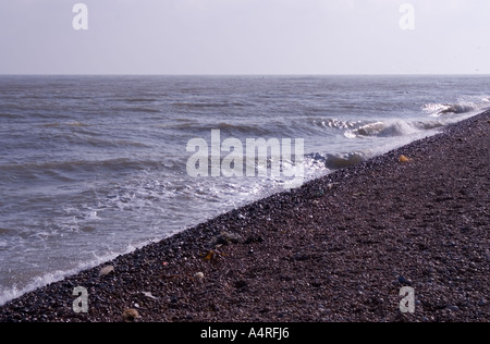 Vagues sur la plage de galets sombres à Dungeness, dans le Kent Banque D'Images