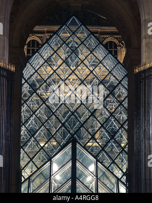 Pyramides de verre au musée du Louvre, Paris France, vue à travers une arche en pierre. Banque D'Images