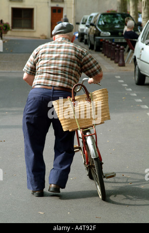 Vieil homme à vélo dans Capestang une petite ville dans une région viticole sur le Canal du Midi dans le sud de la France Banque D'Images