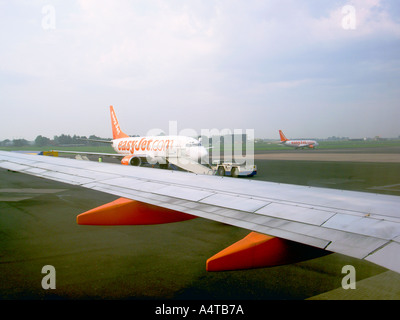 Trois couleurs d'Easyjet avion court-courrier sur l'aire de l'aéroport et la préparation de la piste pour le décollage Banque D'Images