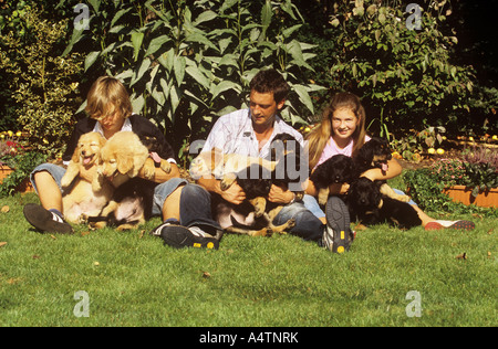 L'homme avec les enfants avec les chiots Hovawart Banque D'Images