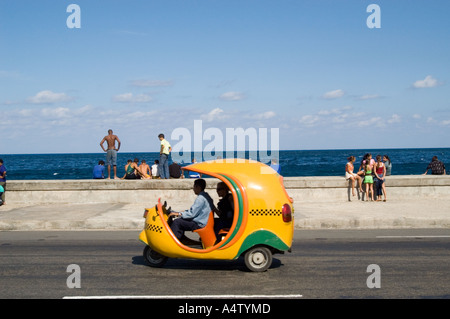 Une promenade en Coco taxi le long de El Malecon, La Havane Cuba Banque D'Images