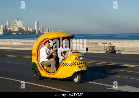 Une promenade en Coco taxi le long de El Malecon, La Havane, Cuba Banque D'Images
