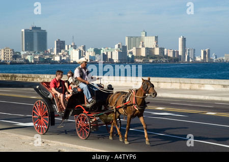 Les touristes à un cheval et balade en calèche le long de El Malecon, La Havane, Cuba Banque D'Images