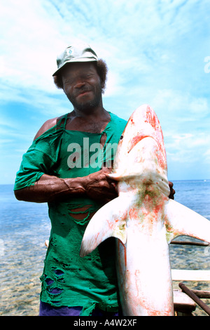 Un requin appelant de Kontu village sur la côte ouest de l'Irlande nouvelle apporte dans un requin qu'il a capturé Banque D'Images