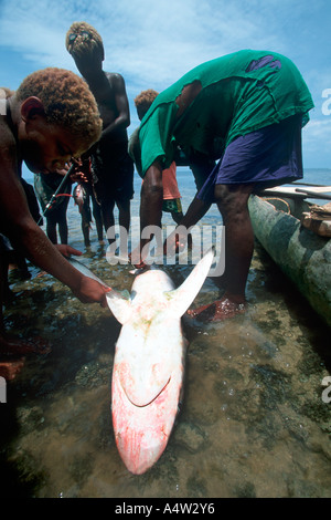 Un requin Obet appelant de Kontu village est entouré d'enfants excités après avoir présenté un requin qu'il a capturé Banque D'Images