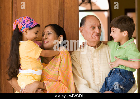 Couple holding leurs petits-enfants dans une entrée de porte Banque D'Images