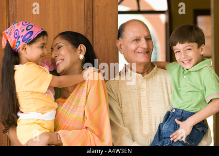 Couple holding leurs petits-enfants dans une entrée de porte Banque D'Images