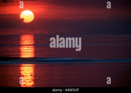 Robert un requin appelant de Kontu paddles jusqu'à la limite du récif au coucher du soleil pour faire des incantations de lui apporter chance dans sa hun Banque D'Images