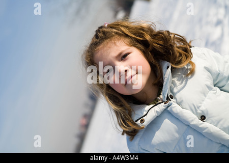 Petite fille blonde au parc couvert de neige Banque D'Images