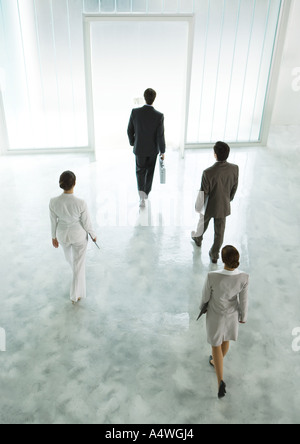 Quatre cadres de marcher à travers hall vers la sortie Banque D'Images