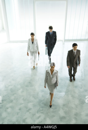 Quatre cadres marche à travers office building hall Banque D'Images