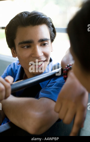 Adolescent parlant à un ami sur le bus Banque D'Images