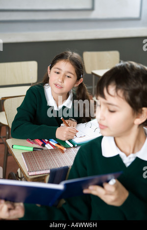 Jeune étudiant montrant outre de son oeuvre dans la classe Banque D'Images