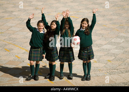 De jeunes étudiants tout en agitant holding soccer ball in courtyard Banque D'Images