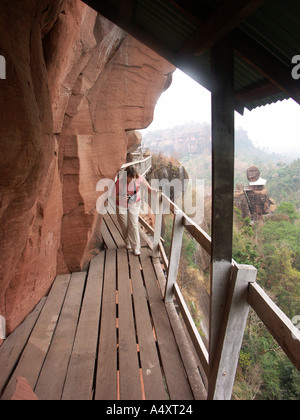 Un touriste négocie la passerelle branlante au-dessus de la plaine du nord est de la Thaïlande autour de Wat Phu Tok Banque D'Images