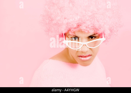 Femme portant une perruque rose et des lunettes Banque D'Images