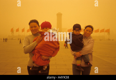 Deux mères chinoises tiennent chaque bébé sur la place Tiananmen pendant une grosse tempête de sable à Beijing, en Chine.20-Mar- 2002 Banque D'Images