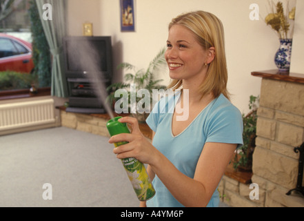 Femme de chambre de pulvérisation avec un désodorisant Banque D'Images