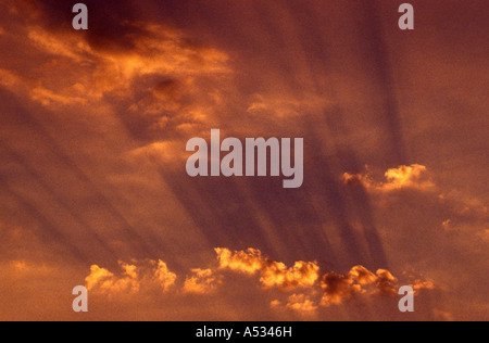 Rayons de soleil dans un ciel rouge sur Suffolk UK Banque D'Images