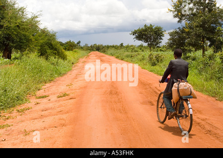 L'homme à vélo sur une piste de terre typique route près d'Muzamanzi, Malawi, Afrique Banque D'Images