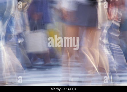 Jambes floues de personnes traversant street Banque D'Images