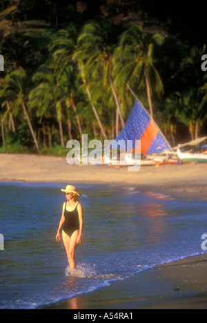 Femme marchant le long de la plage de Pantai sur l'île de Lombok Nipah Modèle Indonésie Photo Parution Banque D'Images