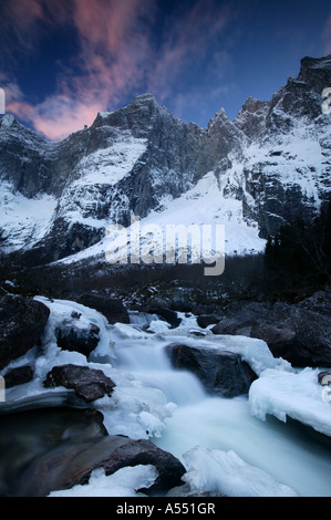 Ciel coloré à l'aube au-dessus du mur de Troll dans la vallée de Romsdalen, Møre og Romsdal fylke, la Norvège. Banque D'Images