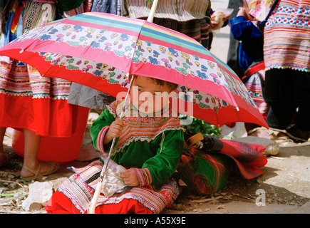 Un enfant hmong de l'abris de soleil sous un parapluie à BacHa nord du Vietnam Banque D'Images