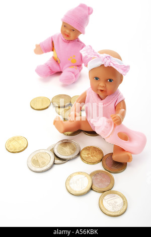 Deux doll assis parmi les pièces en euros Banque D'Images