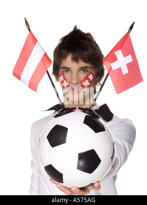 Jeune homme avec drapeau suisse peint sur le visage et le holding football Banque D'Images