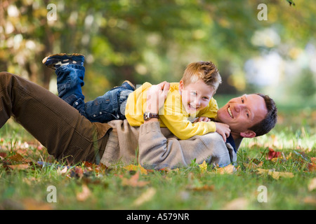 Père jouant avec fils en prairie, side view Banque D'Images