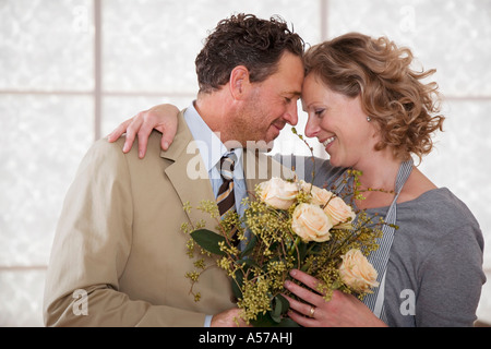 D'âge mûr en cuisine avec bouquet de fleurs Banque D'Images